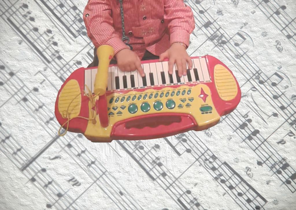 un bambino suona una tastierina, sullo sfondo uno spartito musicale con effetto sfocato e dipinto