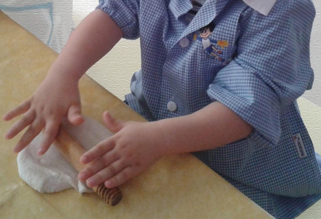 un bambino che stende la pasta per la pizza, sfondo stile quadro di tela