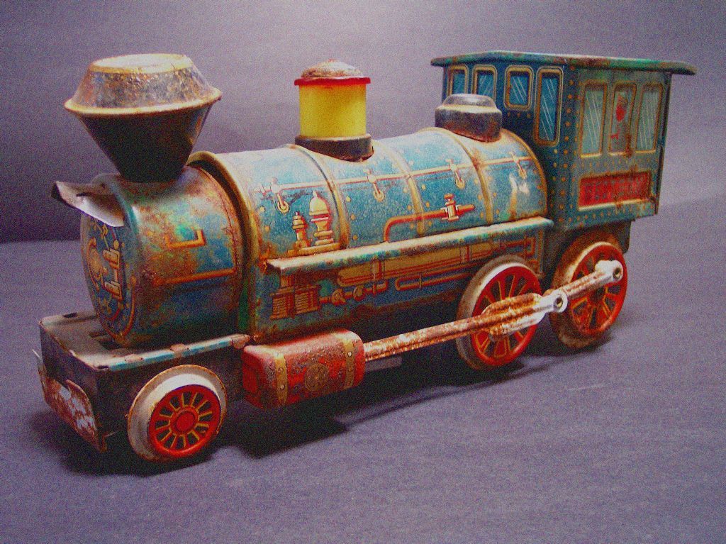 fotografia di un vecchio trenino di latta con effetto anticato e a pennellate